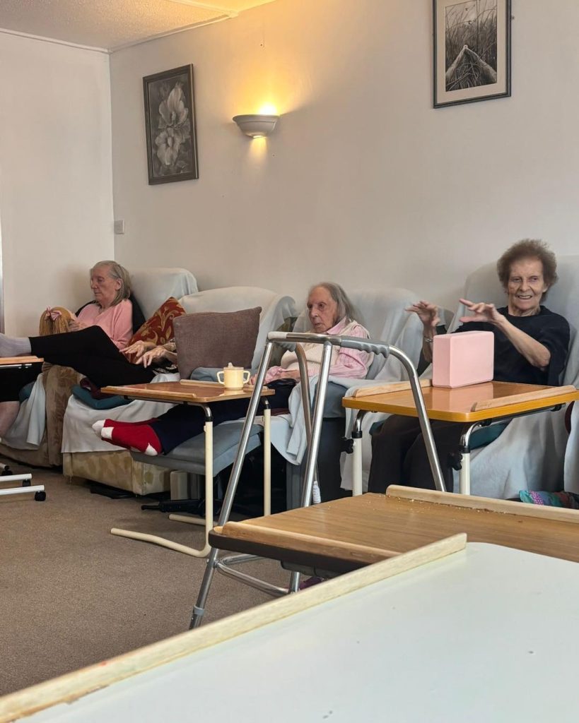 Residents participating in gentle chair exercises indoors