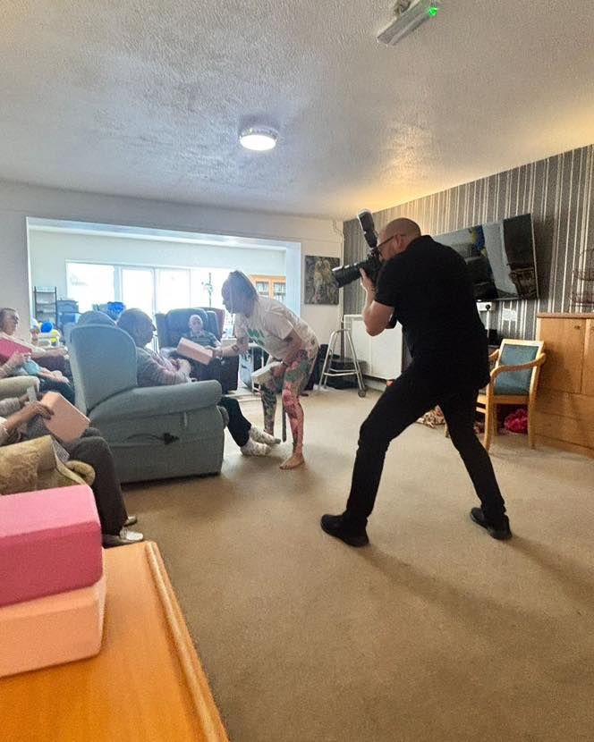Photographer capturing a care home activity as residents interact with foam blocks.