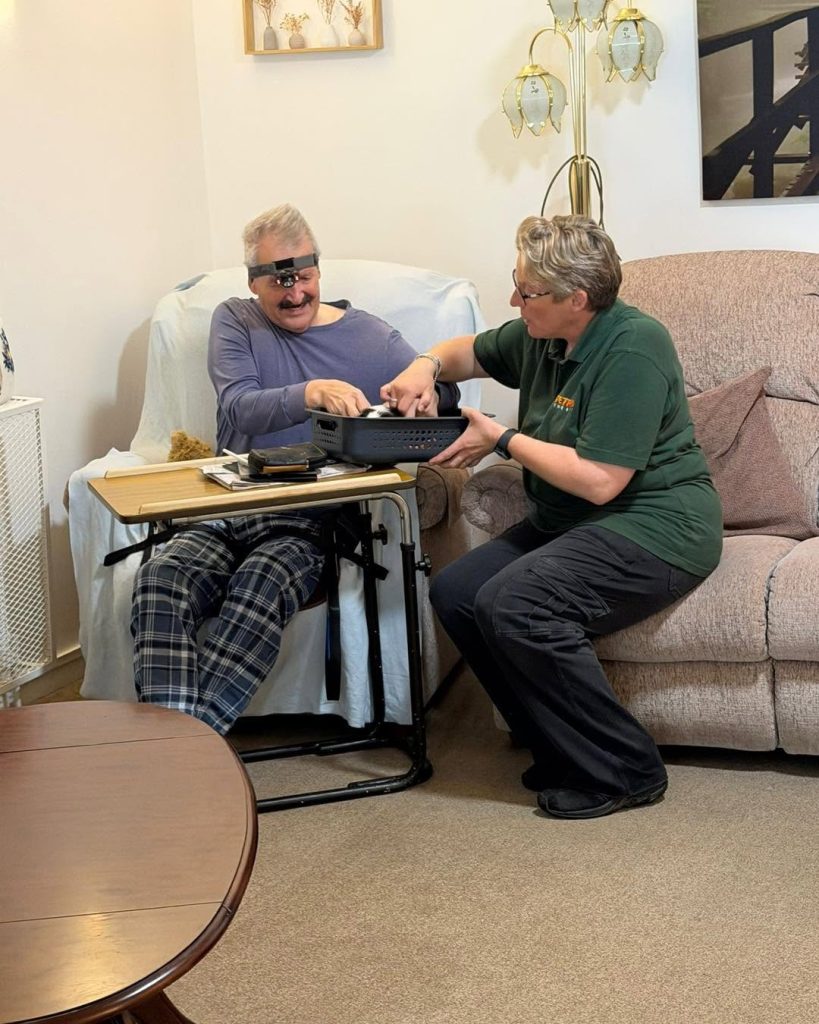 Care staff helping a resident interact with a small therapy animal during a wellbeing activity.