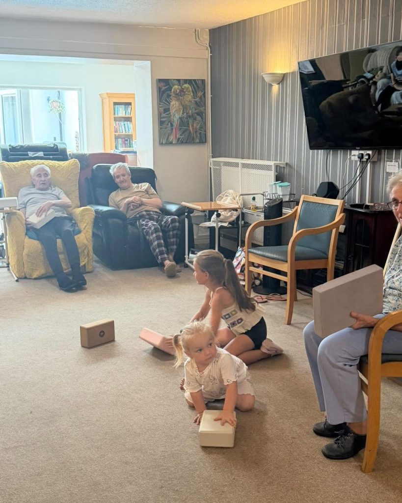 Residents and children enjoying an interactive activity in the lounge.